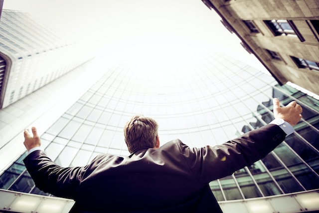 man in the middle of buildings looking up - featured image